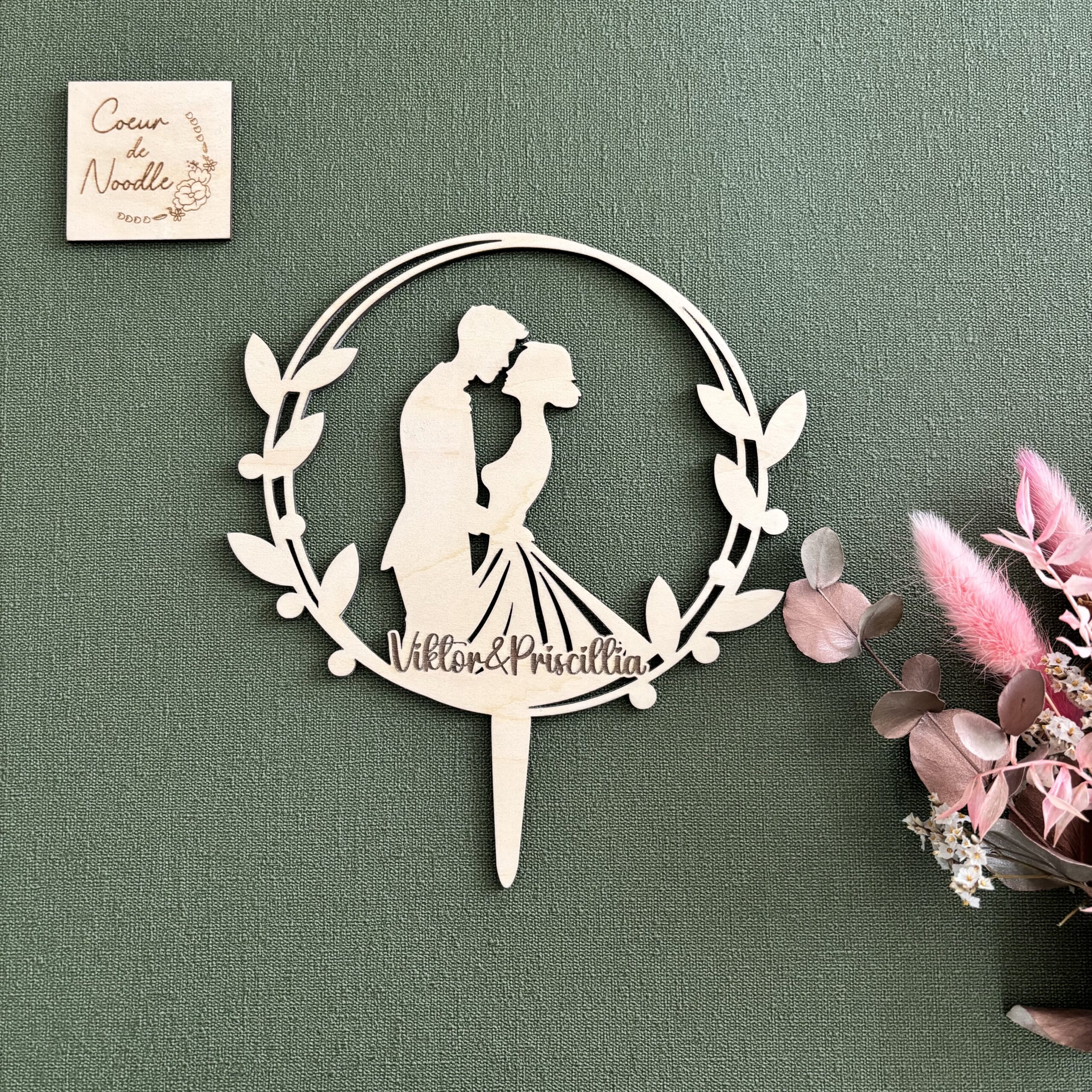 Cake topper mariage avec un couple, sur fond vert.